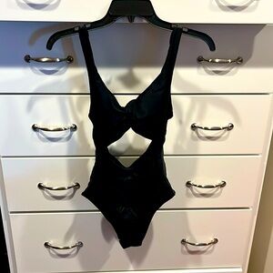 Black one piece bathing suit with cut-out front. Size M